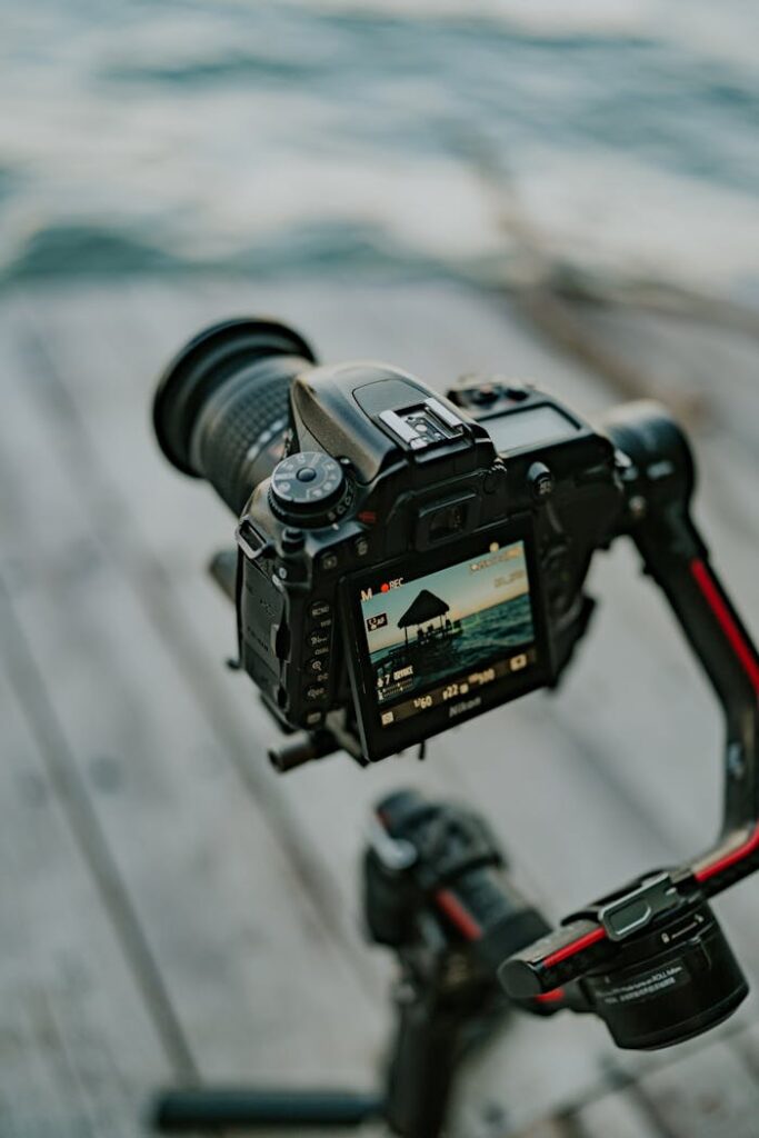 A camera on a tripod with a view of the ocean